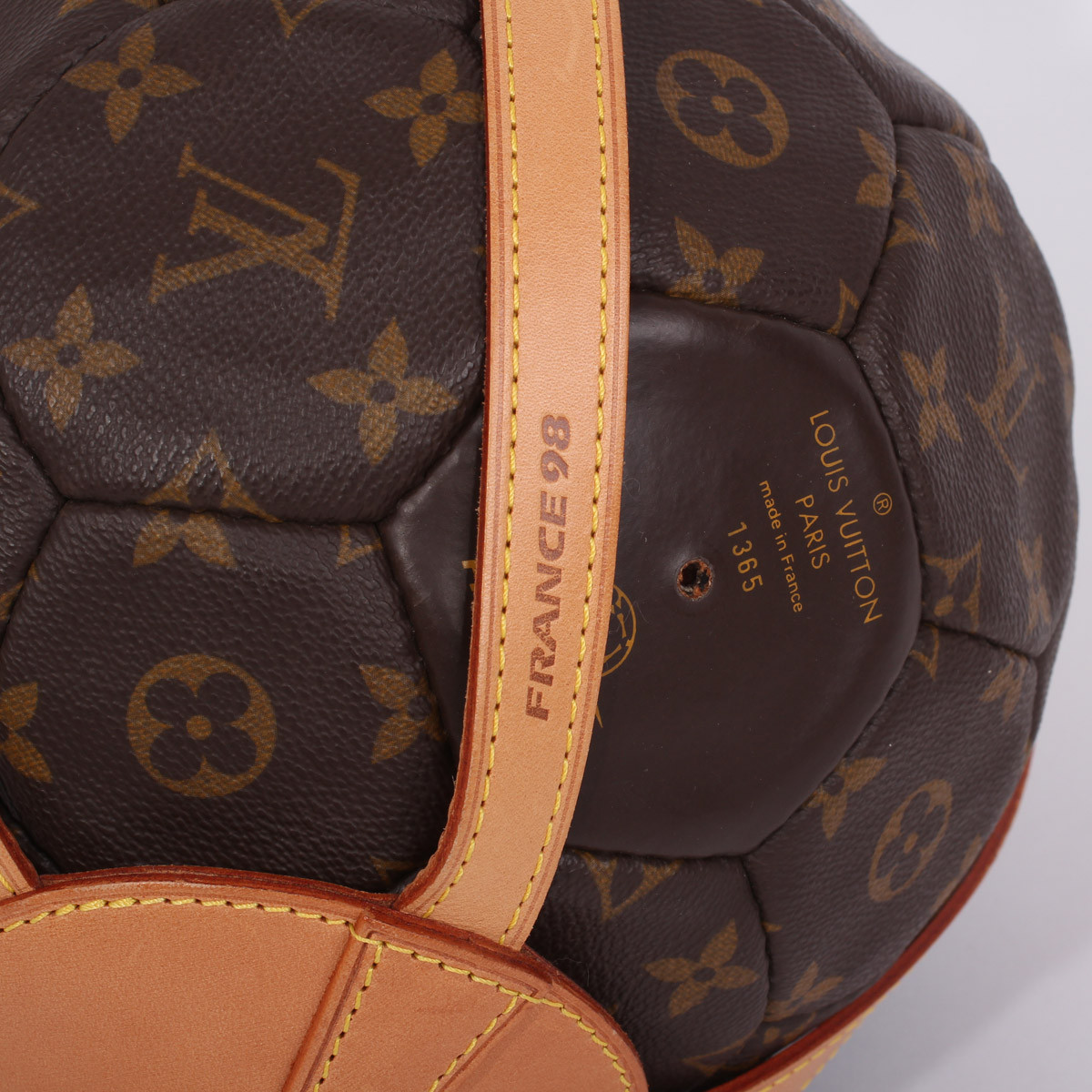 A limited edition monogrammed soccer ball with leather holder made by Louis  Vuitton for the World Cup in France in 1998. Together with a copy of  Rebonds, a limited edition Louis Vuitton