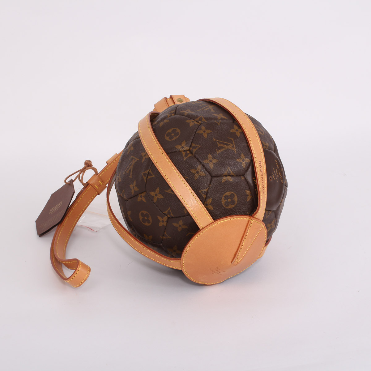 A limited edition monogrammed soccer ball with leather holder made by Louis  Vuitton for the World Cup in France in 1998 Together with a copy of  Rebonds a limited edition Louis Vuitton